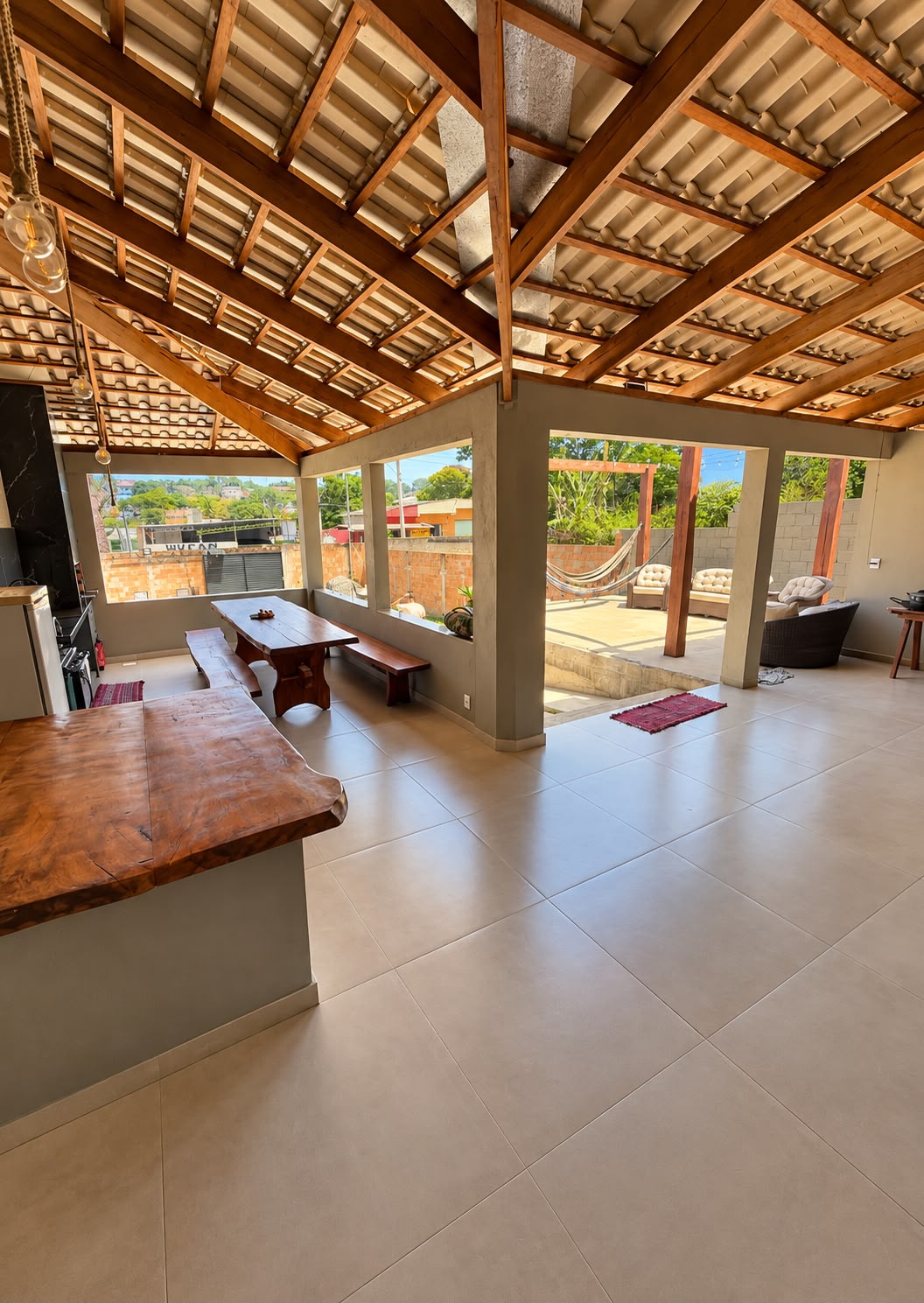 Villa Acácia — área gourmet coberta com mesa de madeira e bancada